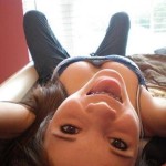 young teen daughter laying in bed braces tongue out for daddy